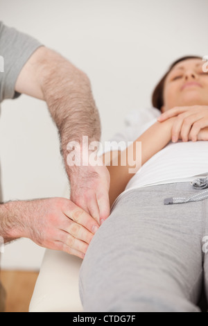 Physiotherapeut, Massage der Oberschenkel seines ruhigen Patienten Stockfoto