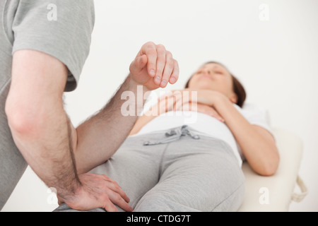 Masseur massiert den Oberschenkel einer Frau Stockfoto