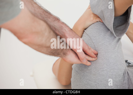 Arzt mit seinen Fingerspitzen um einen Schenkel zu massieren Stockfoto