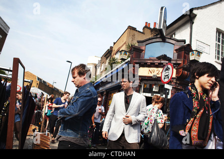 Zwei Männer shop Kleidung aus zweiter Hand in einem Stall vor dem Pub die Taube. Stockfoto