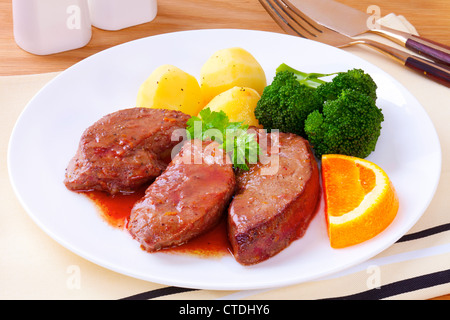 Lamm Leber oder Lamm braten, gekocht in einer Sauce aus Wein und Orange, serviert mit neuen Kartoffeln und Brokkoli. Stockfoto