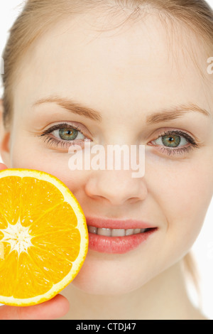 Nahaufnahme einer Frau platzieren eine Orange auf den Lippen Stockfoto