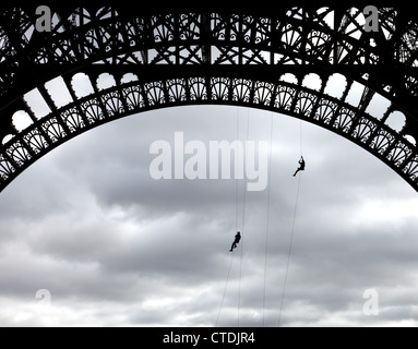 Paris, Frankreich: Paris Feuerwehr üben Sie ihre Fähigkeiten aus einem Basis Bogen des Eiffelturms. Stockfoto