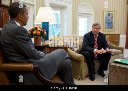 US-Präsident Barack Obama auf den administrativen Aufwand zur Bewältigung der historischen Trockenheit spürbar über dem Land bei einem Treffen im Oval Office 18. Juli 2012 in Washington, DC vom Landwirtschaftsminister Tom Vilsack unterrichtet ist. Stockfoto