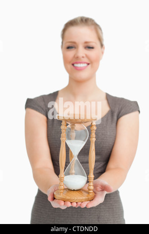 Frau, Lächeln, zeigt eine Sanduhr Stockfoto