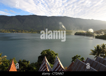 Die Spitzen Dächer der traditionellen Batak Häuser sichtbar mit Blick auf Bagus Bay auf der Insel Samosir, Lake Toba. Stockfoto