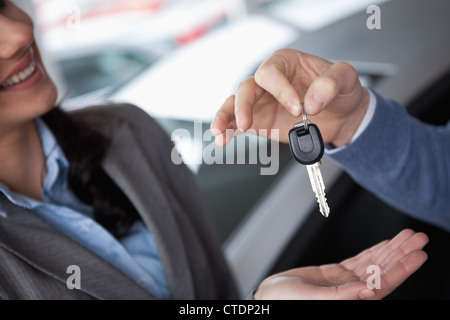 Lächelnde Frau empfangende Schlüssel von einer Person Stockfoto