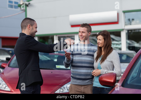 Verkäufer ein paar Autoschlüssel geben Stockfoto