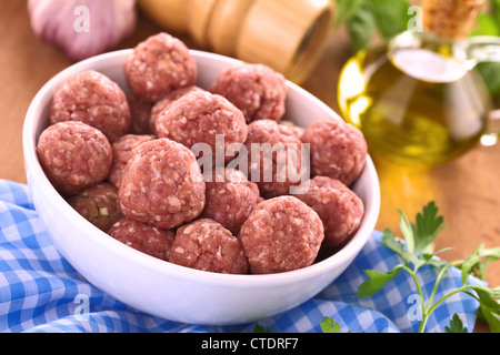 Rohe Frikadellen mit Knoblauch in einer weißen Schüssel (selektiven Fokus, Fokus auf die Frikadellen in der Front) Stockfoto