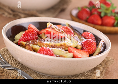 Schupfnudeln (schwäbische Kartoffel Nudeln aus Süddeutschland) mit frischen Erdbeeren, Zucker und Zimt Pulver Stockfoto