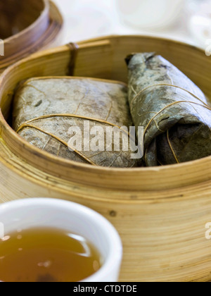 Gedämpfte chinesischer Reis Knödel in Bambusblätter gewickelt. Stockfoto