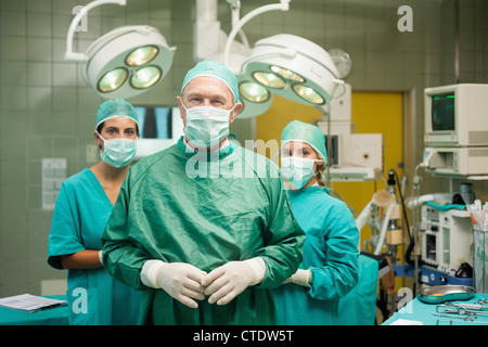 Chirurg an der Hand mit zwei Praktikanten hinter ihm Stockfoto