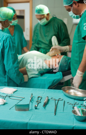 Chirurgie-Trolley mit chirurgischen Werkzeugen vor ein medizinisches team Stockfoto