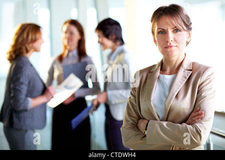 Porträt einer ausgereiften Business-Dame stehen im Vordergrund, ihre weiblichen Kollegen haben einen Vortrag im Hintergrund Stockfoto