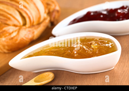 Orange und Erdbeere Marmelade mit Croissant (selektiven Fokus, Fokus auf der Vorderseite des Orangenkonfitüre auf der rechten Seite des Bildes) Stockfoto