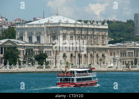 ISTANBUL, TÜRKEI. Ein Ausflugsschiff geht Dolmabahce Palast im Stadtteil Besiktas am europäischen Ufer des Bosporus. 2012. Stockfoto