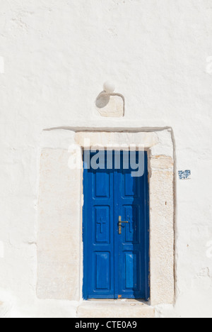 Blaue Tür in einem weiß getünchten Mauer der Kirche auf der Insel Serifos, Kykladen, Griechenland Stockfoto