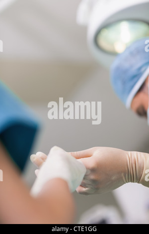 Nahaufnahme einer Krankenschwester eine chirurgische Schere zu einem Arzt geben Stockfoto