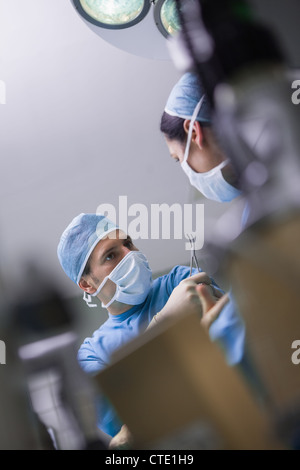 Ernst Arzt, einer Krankenschwester und eine chirurgische Schere verleiht Stockfoto
