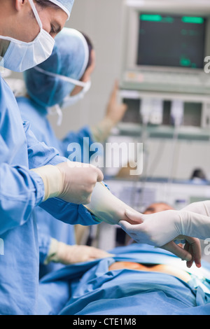 Arzt seine Handschuhe entfernen Stockfoto