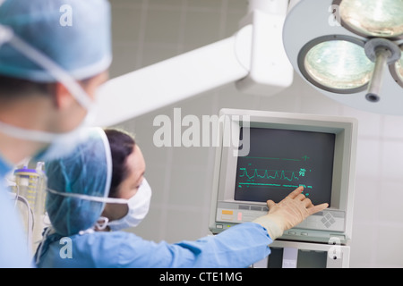 Arzt den ECG Monitor zeigt Stockfoto