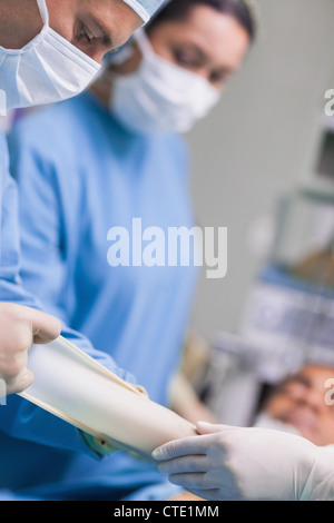 Arzt seine Handschuhe während der Operation zu entfernen Stockfoto