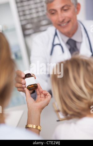 Arzt geben eine Flasche von Drogen Stockfoto