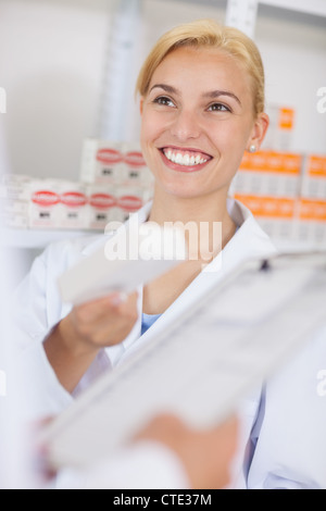 Blonde Apotheker hält eine Droge-Box während lächelnd Stockfoto