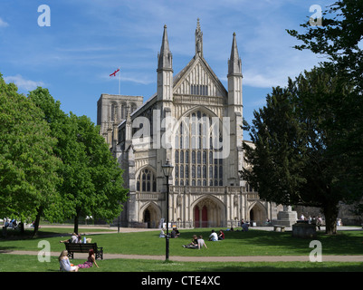 dh Winchester Cathedral WINCHESTER HAMPSHIRE Menschen entspannen sich auf dem Rasen vor der Kathedrale West End Eingang alten Münster england großbritannien Stockfoto