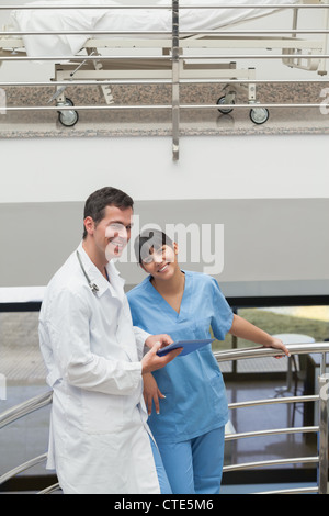 Arzt hält einen Tablet-Computer neben einer Krankenschwester Stockfoto