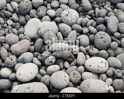 Kieselsteine aus Lavastein, abgerundet durch Walzen in den Wellen an den Stränden von Lanzarote Stockfoto