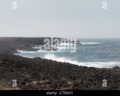 Wellen brechen sich am Lava Felsen auf der West Küste von Lanzarote Stockfoto