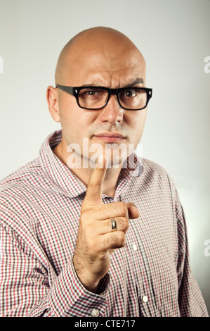 Junger Geschäftsmann mit schweren sieht ein Fingerzeig und threating. Gemeinsame Geste der Warnung, warnt und threating. Stockfoto