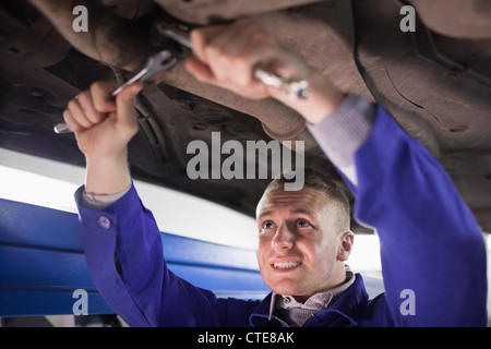Mechaniker, ein Auto zu reparieren, während Sie mit Werkzeugen Stockfoto
