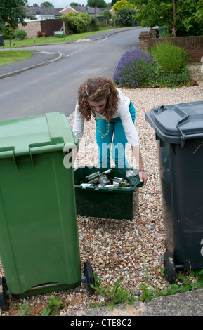 Junge Frau hält eine Schachtel mit Glasflaschen und Gläser für das recycling Stockfoto