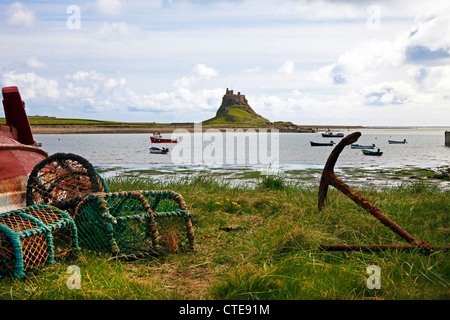 Lindisfarne Schloß vom Hafen mit Hummer Töpfe und rostigen Anker, Northumberland, England, UK Stockfoto