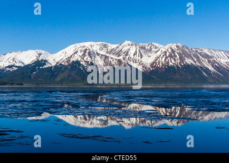 Spiegelungen von schneebedeckten Bergen in wunderschönen blauen eisigen Gewässern von Turnagain Arm, einer Abzweigung von Cook Inlet in Anchorage, Alaska. Stockfoto