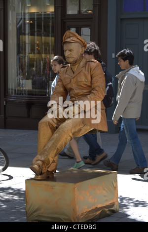 London, Covent Garden. Eines der vielen Mimers offenbar auf Luft sitzen fasziniert Passanten in dieser beliebten Gegend von London. Stockfoto