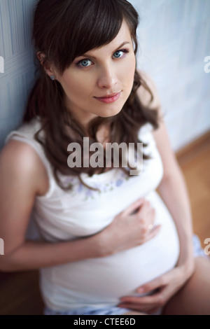 junge schwangere Frau auf dem sofa Stockfoto