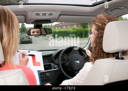 Teenager-Mädchen L Lernenden Halteplatte mit Lehrer übergibt Fahrprüfung Stockfoto