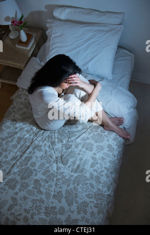 USA, New Jersey, Jersey City, junge Frau sitzt auf Bett Stockfoto