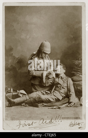 Original Grußkarte aus dem frühen 20. Jahrhundert, Postkarte des Britischen Imperium mit zwei Kindern, die als Soldaten des Boer-Krieges (Südafrikanischer Krieg) verkleidet waren, von denen eines erste Hilfe erhielt - geschrieben am 1902. Oktober aus London, Großbritannien. Stockfoto