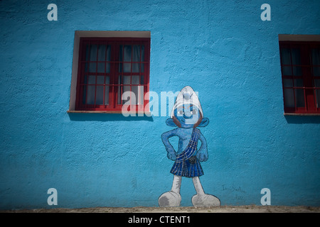 Ein Gemälde von einem Schlumpf mit der schottischen Tracht gekleidet ziert eine Wand in Juzcar, das Schlumpfdorf, Malaga, Spanien Stockfoto