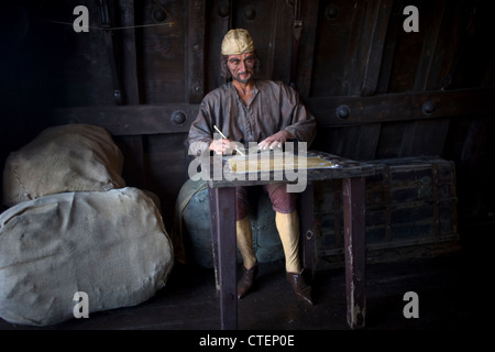 Eine Skulptur eines Seemanns schreiben angezeigt in einer Reproduktion die Karavelle Santa Maria in La Rabida, Palos De La Frontera, Huelva Stockfoto