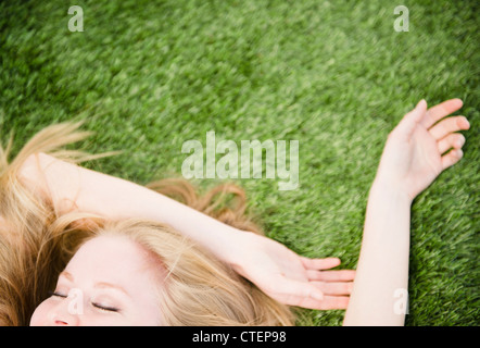 USA, New Jersey, Jersey City, Frau liegt auf dem Rasen Stockfoto