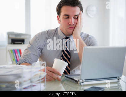 USA, New Jersey, Jersey City, Bored Geschäftsmann auf laptop Stockfoto