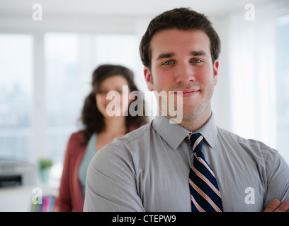 USA, New Jersey, Jersey City, Porträt von Geschäftsmann, Geschäftsfrau im Hintergrund Stockfoto
