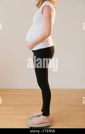 Schwangere Frau auf Waage Stockfoto