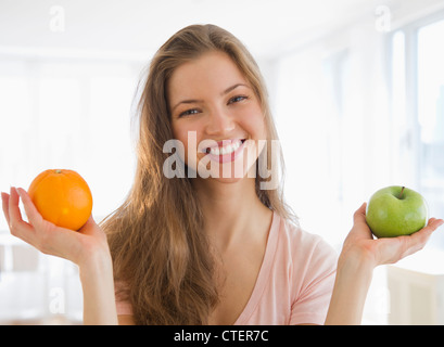 USA, New Jersey, Jersey City, Frau Betrieb Orange und Apfel Stockfoto