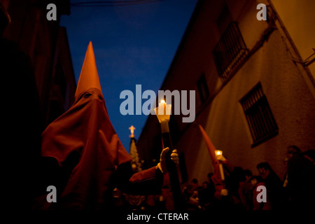 Ein Büßer hält eine Kerze während einer Prozession der Karwoche in Puente Genil, in der Provinz Cordoba, Spanien Stockfoto